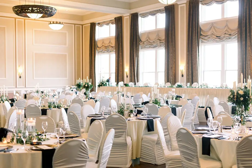 The Hotel Julien ballroom set for the reception, with round tables dressed in white linens, navy sashes, and greenery centerpieces